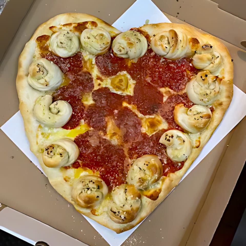 Heart-shaped pepperoni pizza with garlic knot crust, served in a Frank's Pizza box.